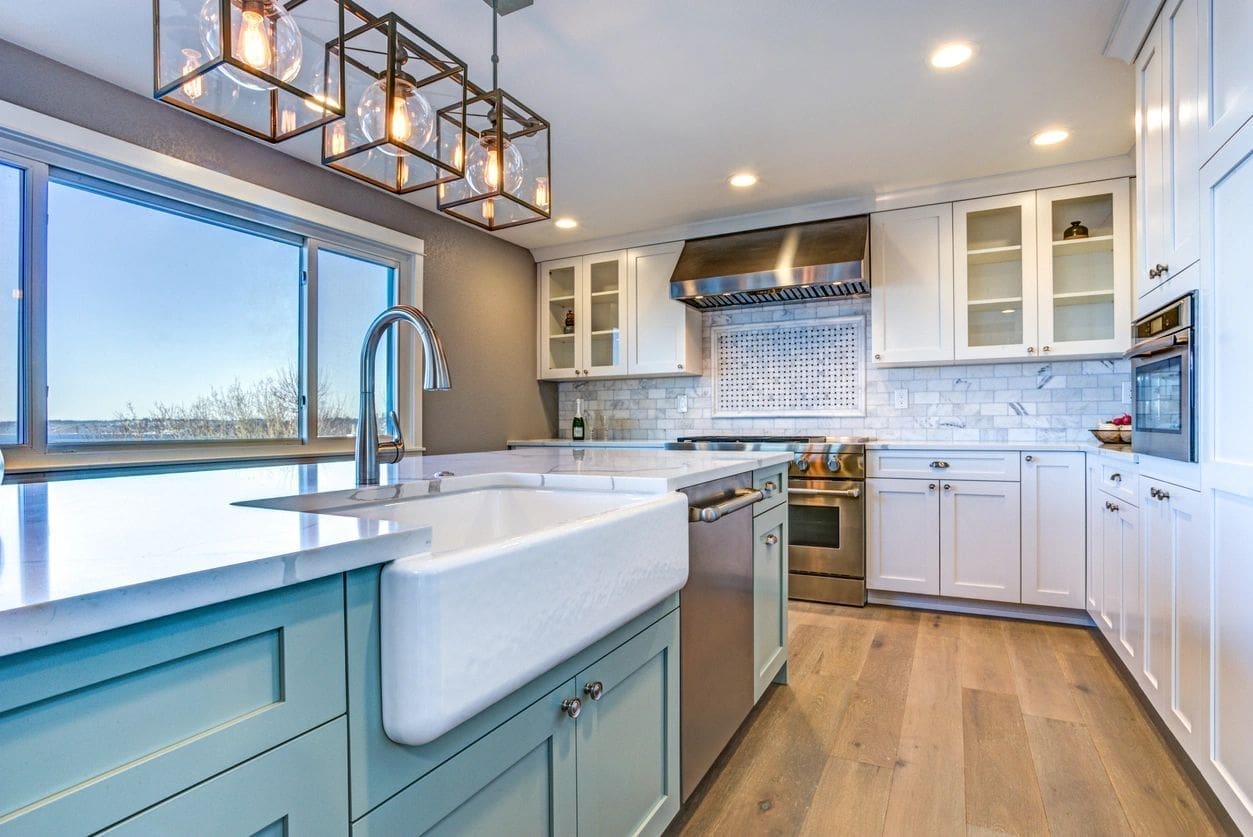 The Brookhaven Butler & Concierge LLC A kitchen with white cabinets and blue island.